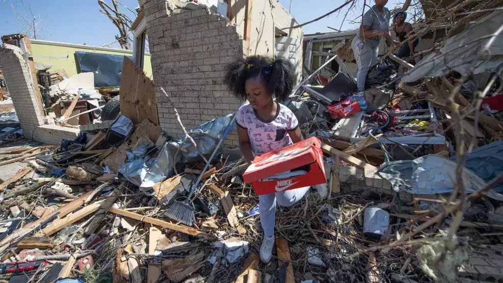 Little girl holding shoe box in mississippi after tornado