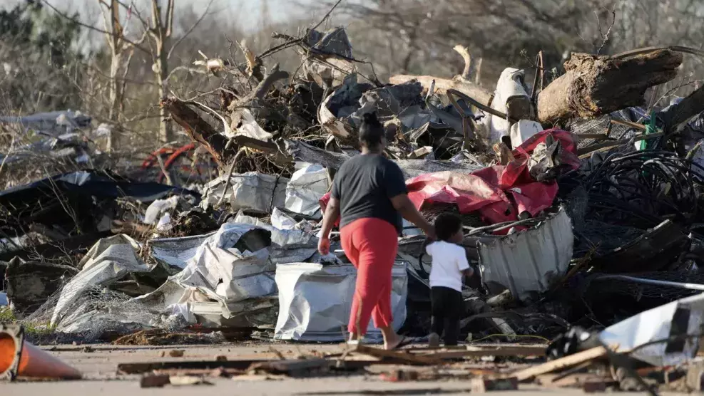 A pair of residents walk through the remains of their tornado-demolished mobile home park, looking through the piles of debris, insulation, and home furnishings to see if anything is salvageable in Rolling Fork, Mississippi, Saturday, March 25, 2023.
