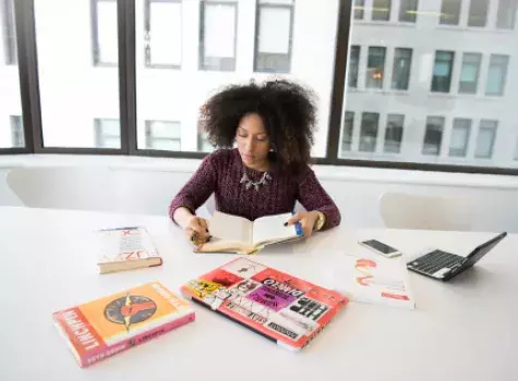 Black Female Reading at Office Table - Solo