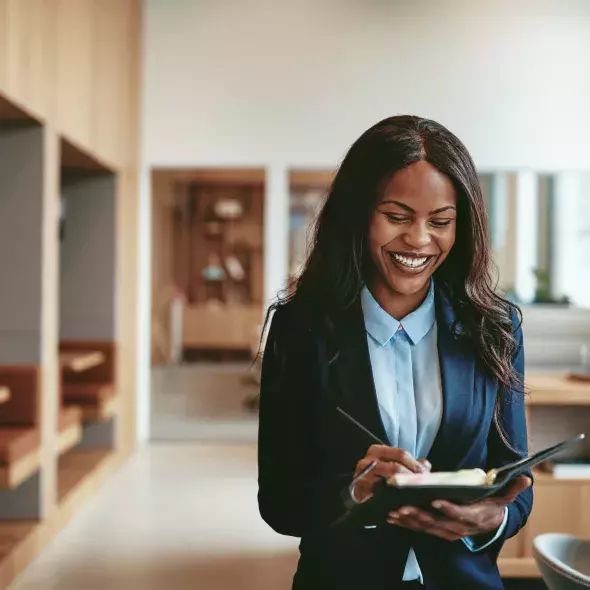 A Black woman in business attire smiles