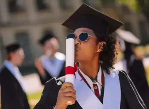 Black Graduate Kissing Rolled-Up Diploma - Outdoors