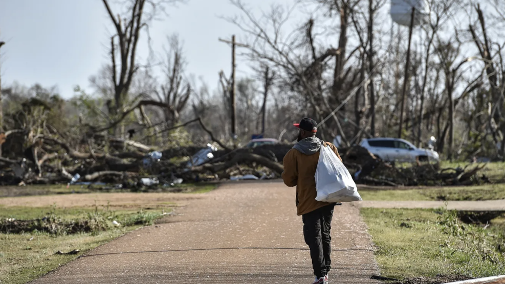 Terry York, a Silver City, Miss., resident, walks through a damaged neighborhood with a small bag of personal belongings, Saturday, March 25, 2023, after a deadly tornado ripped through the area the night before.