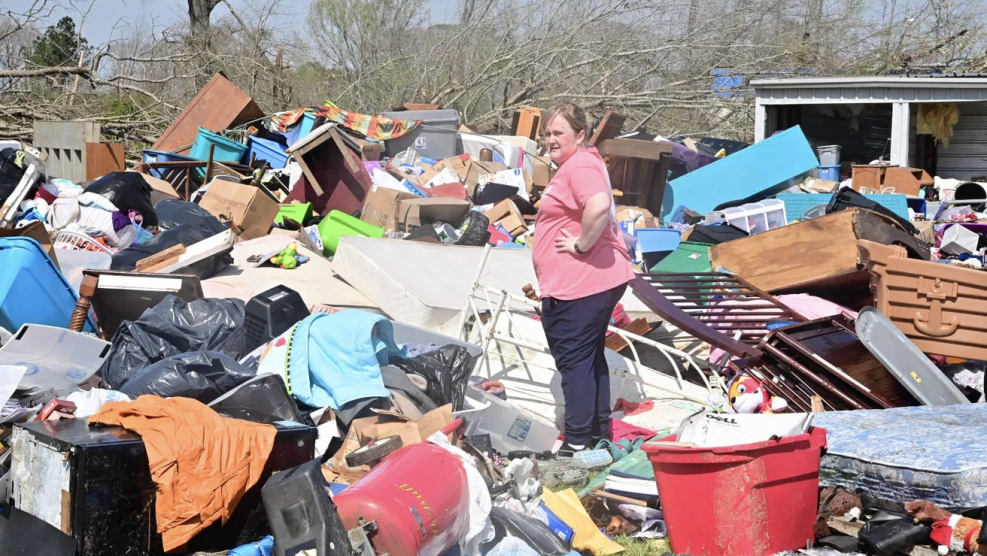 A woman sorts through belongings at a storage facility in Amory after an overnight tornado caused widespread damage.