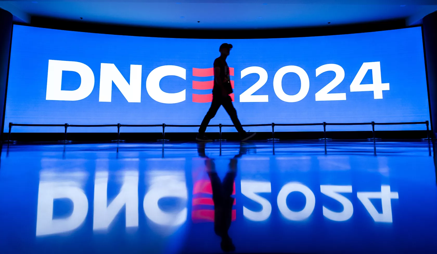 Person walks past DNC digital wall