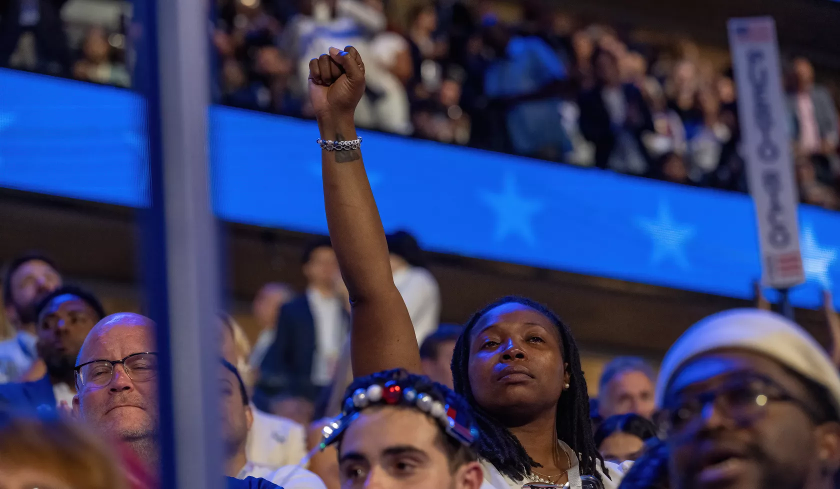 A Black woman holds her fist in the air 