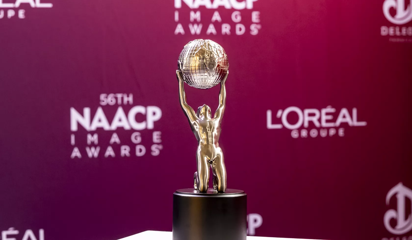 An NAACP Image Awards trophy sits on a podium.