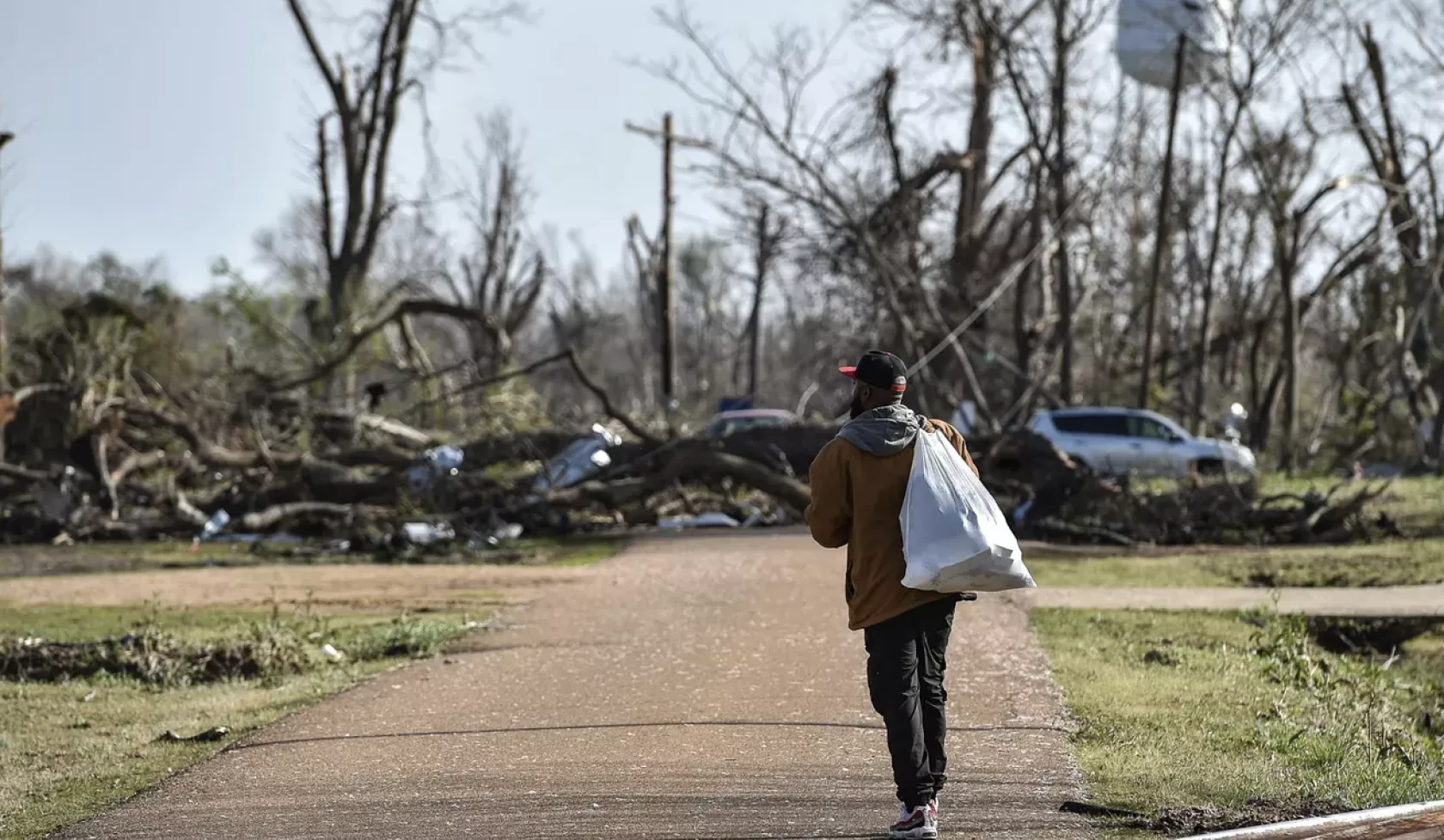 Terry York, a Silver City, Miss., resident, walks through a damaged neighborhood with a small bag of personal belongings, Saturday, March 25, 2023, after a deadly tornado ripped through the area the night before.