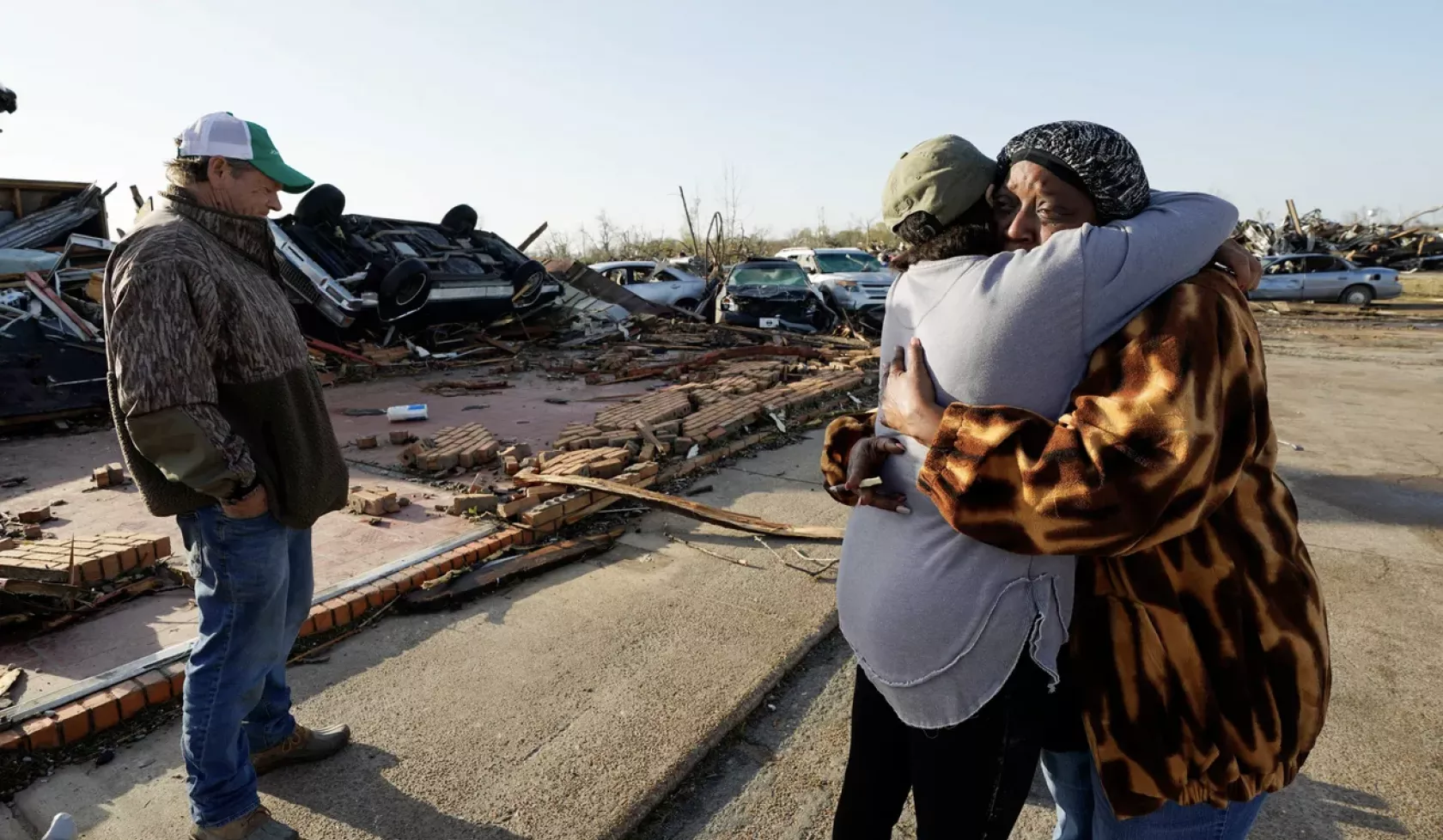 Tracy Hardin, center, who with her husband Tim, left, own Chuck's Dairy Bar, consoles a neighbor in Rolling Fork, Miss., Saturday, March 25, 2023