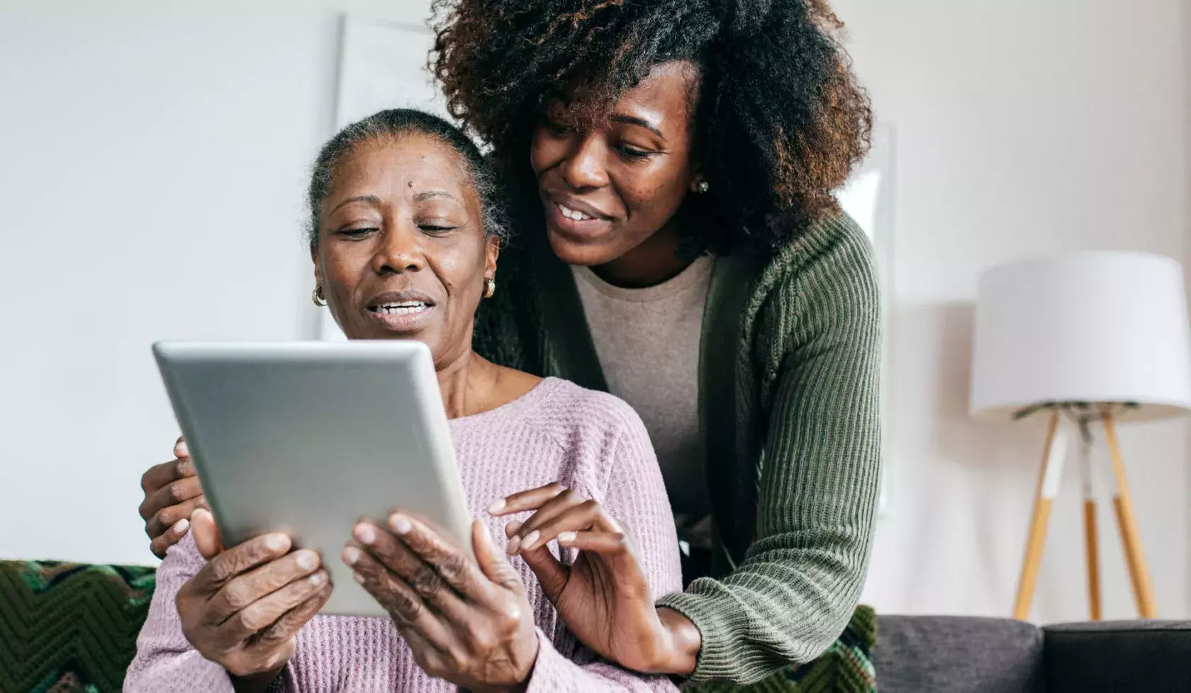 Woman Supporting a Senior with Tablet Technology Use