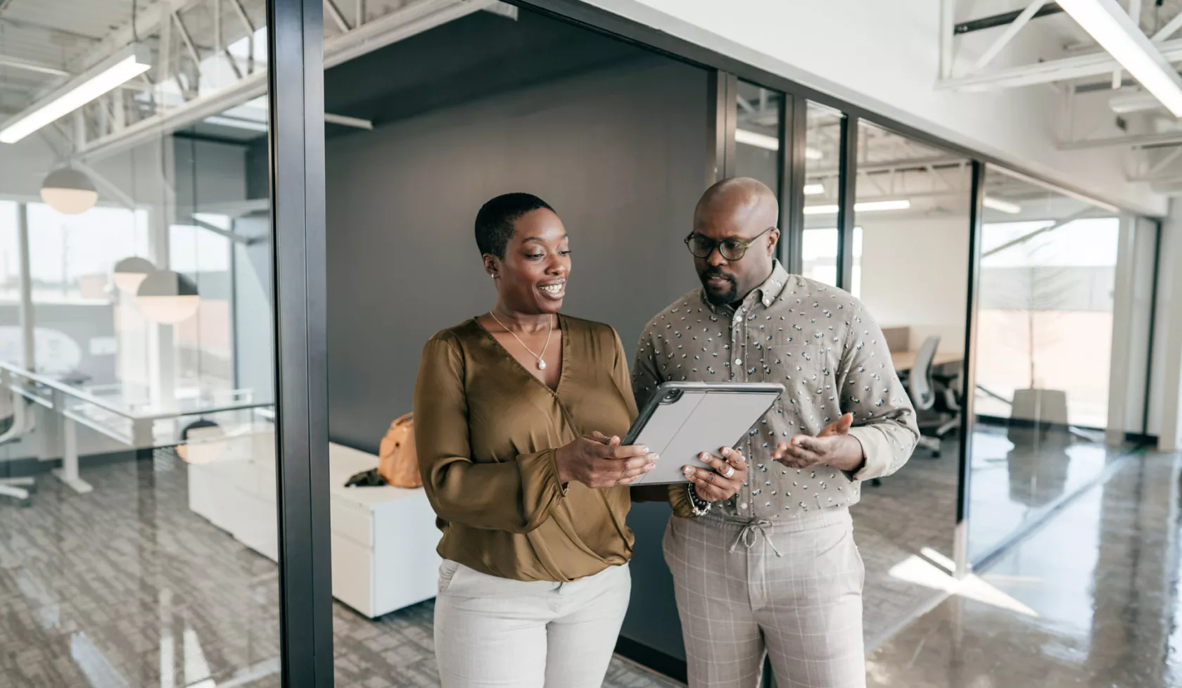 Businesspeople Collaborating Over Tablet In Office Setting