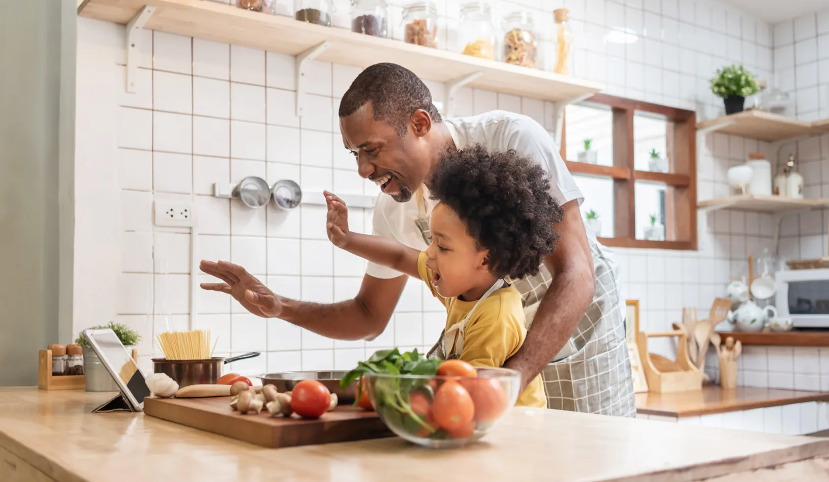 Father and Child Cooking in Kitchen and Waving at Tablet