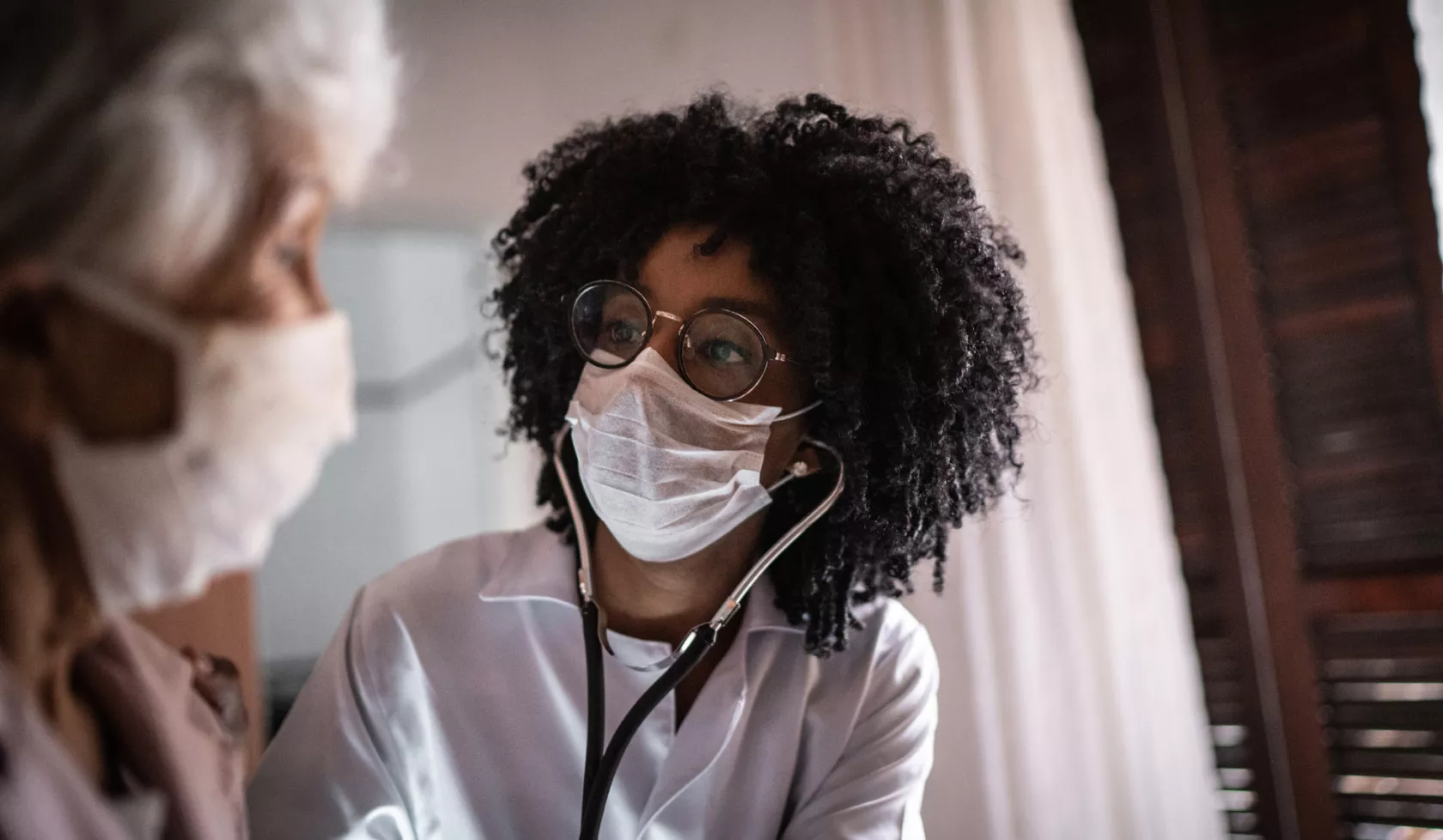 Masked Doctor Using Stethoscope with Patient