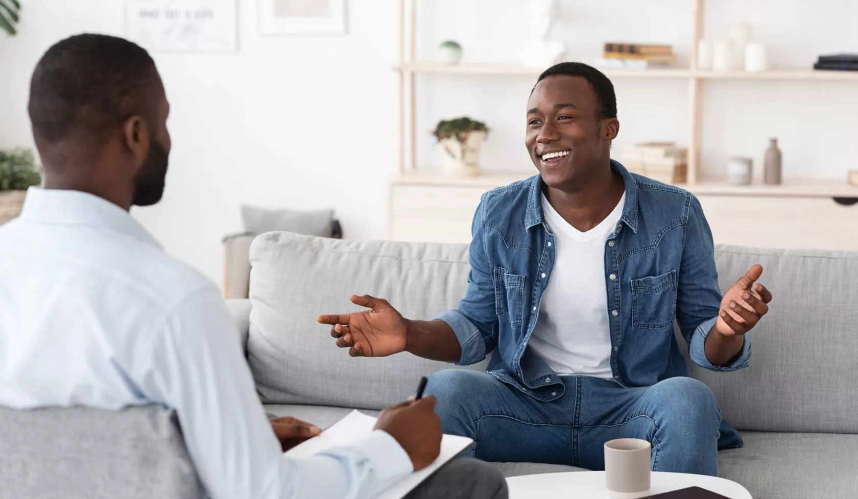 Two Black Men in Conversation and Taking Notes - Inside