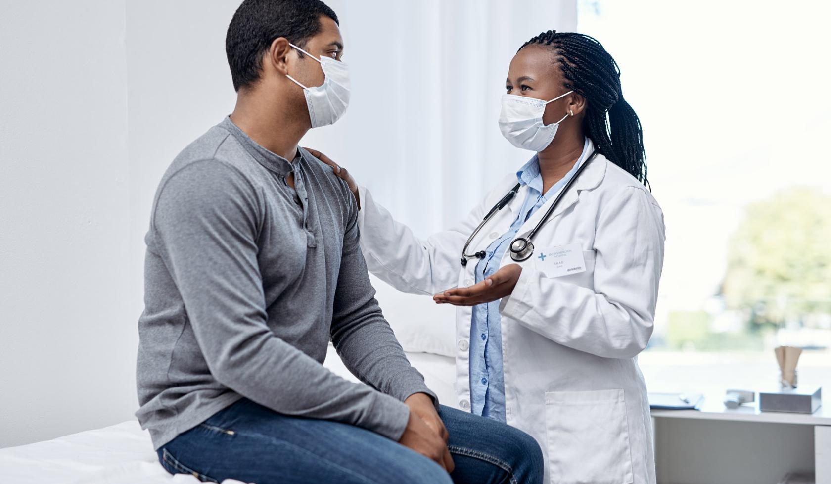 Black Masked Female Doctor Treating a Patient - Indoors