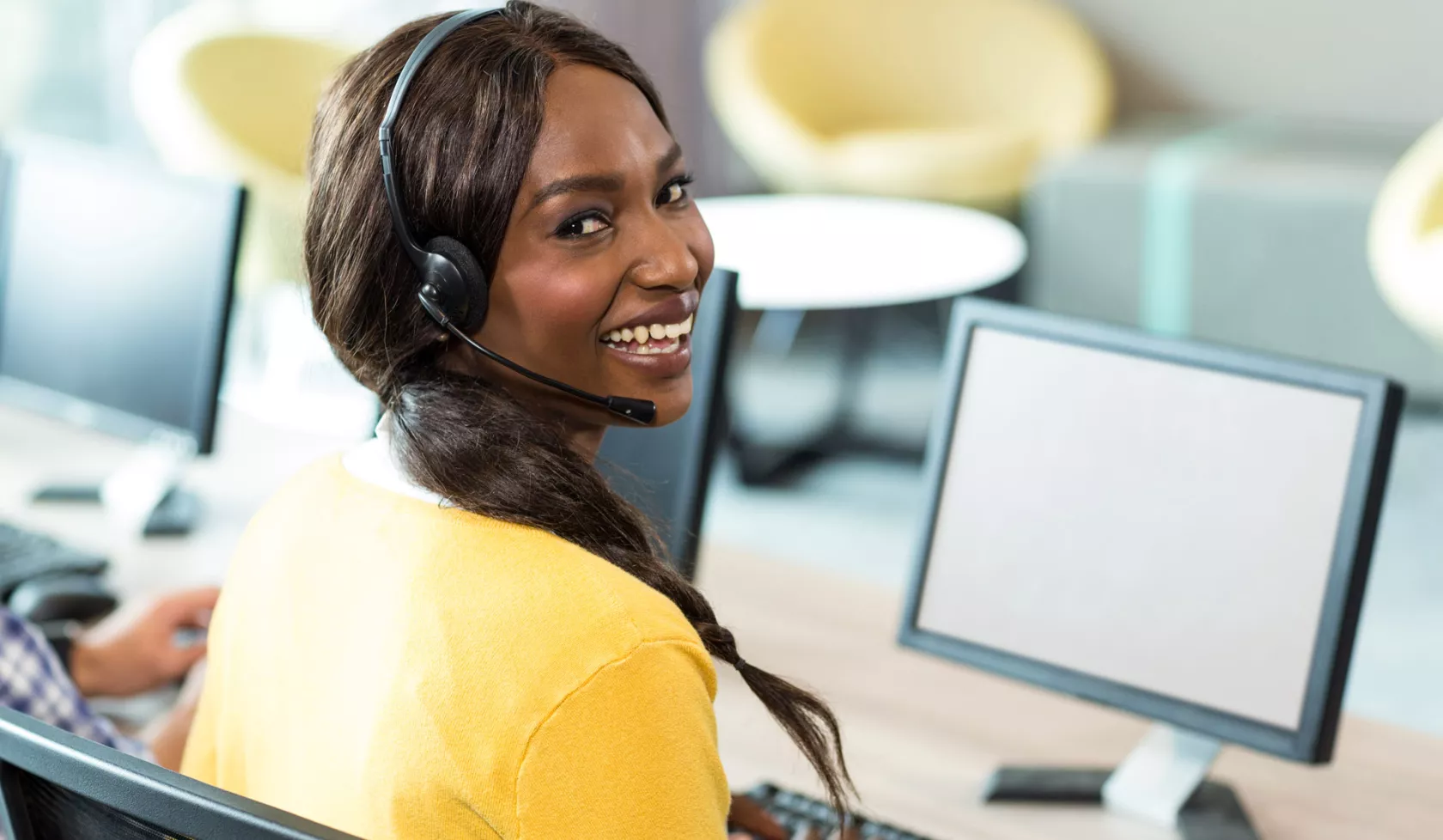 Black Female Professional Working on Computer and Smiling at Camera