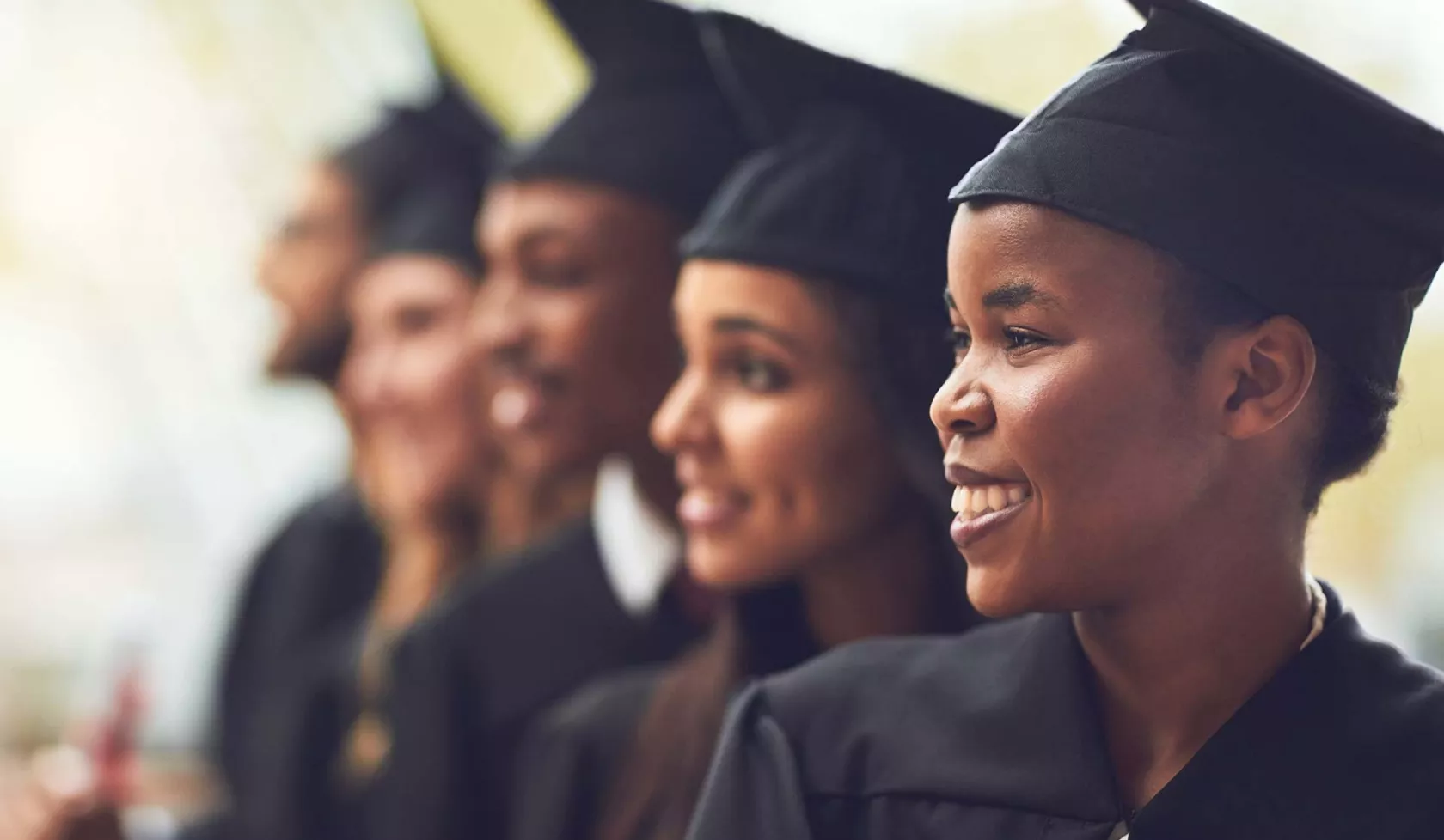 Line of Young Adults in Graduation Caps - Smiling