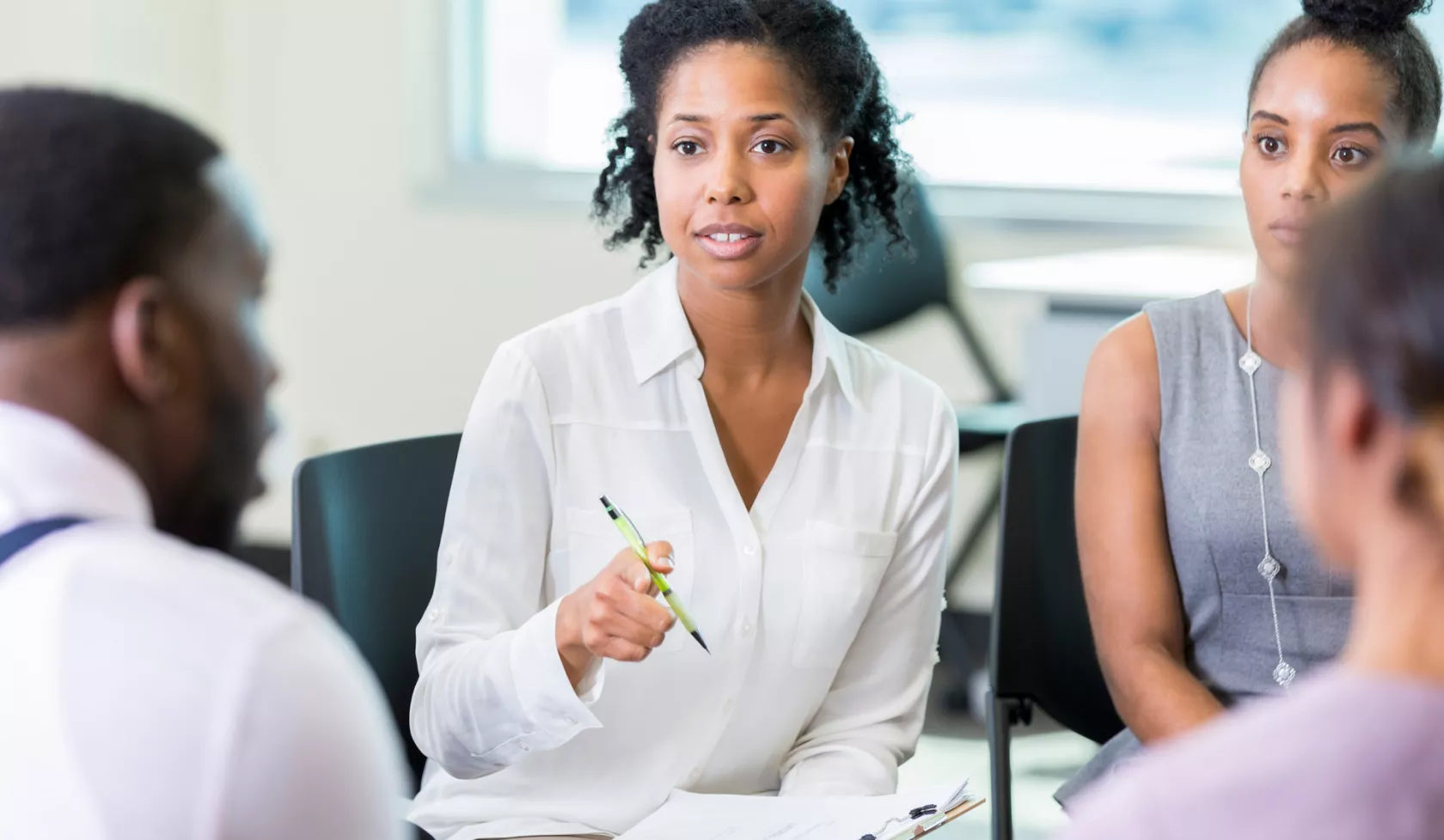 Female Professional Speaking to a Seated Group of People