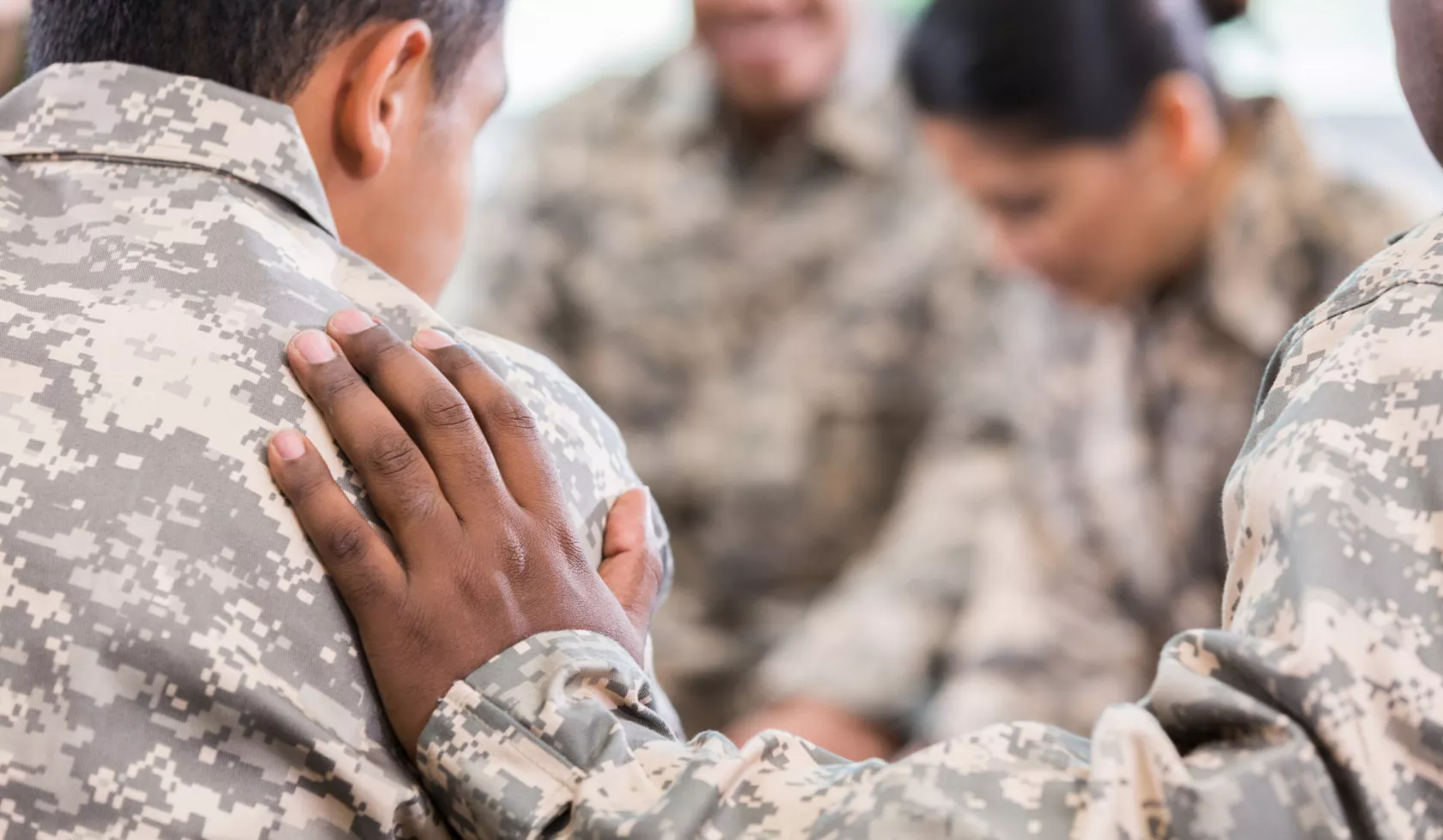 Close-up of Hand on Shoulder Amongst Military Personnel