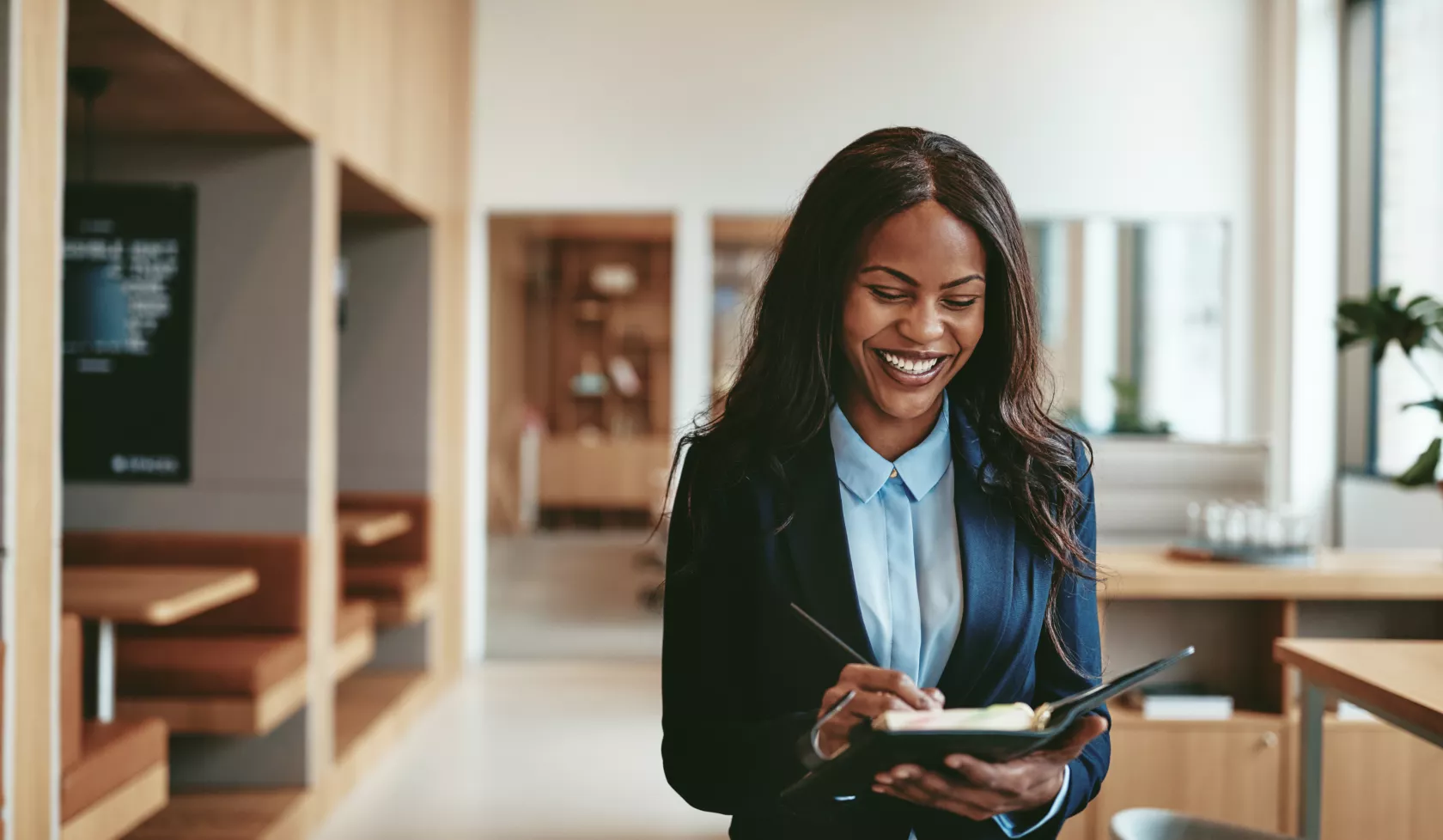 A Black woman in business attire smiles