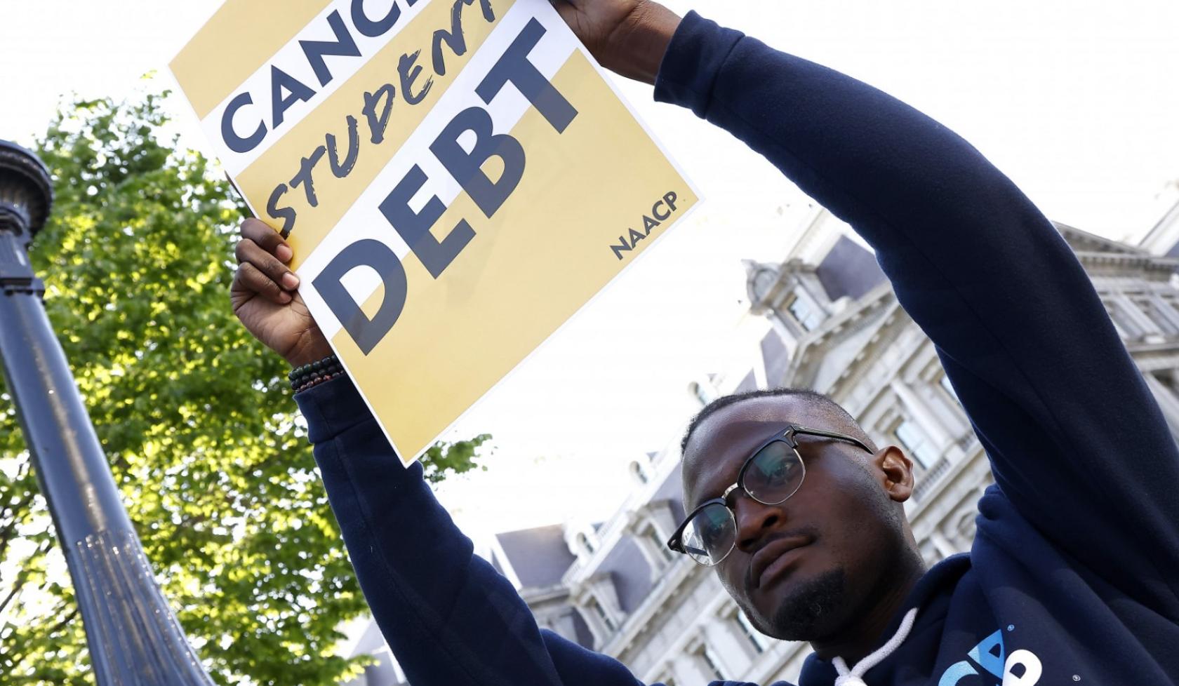 Wisdom Cole - Holding Cancel Student Debt Sign