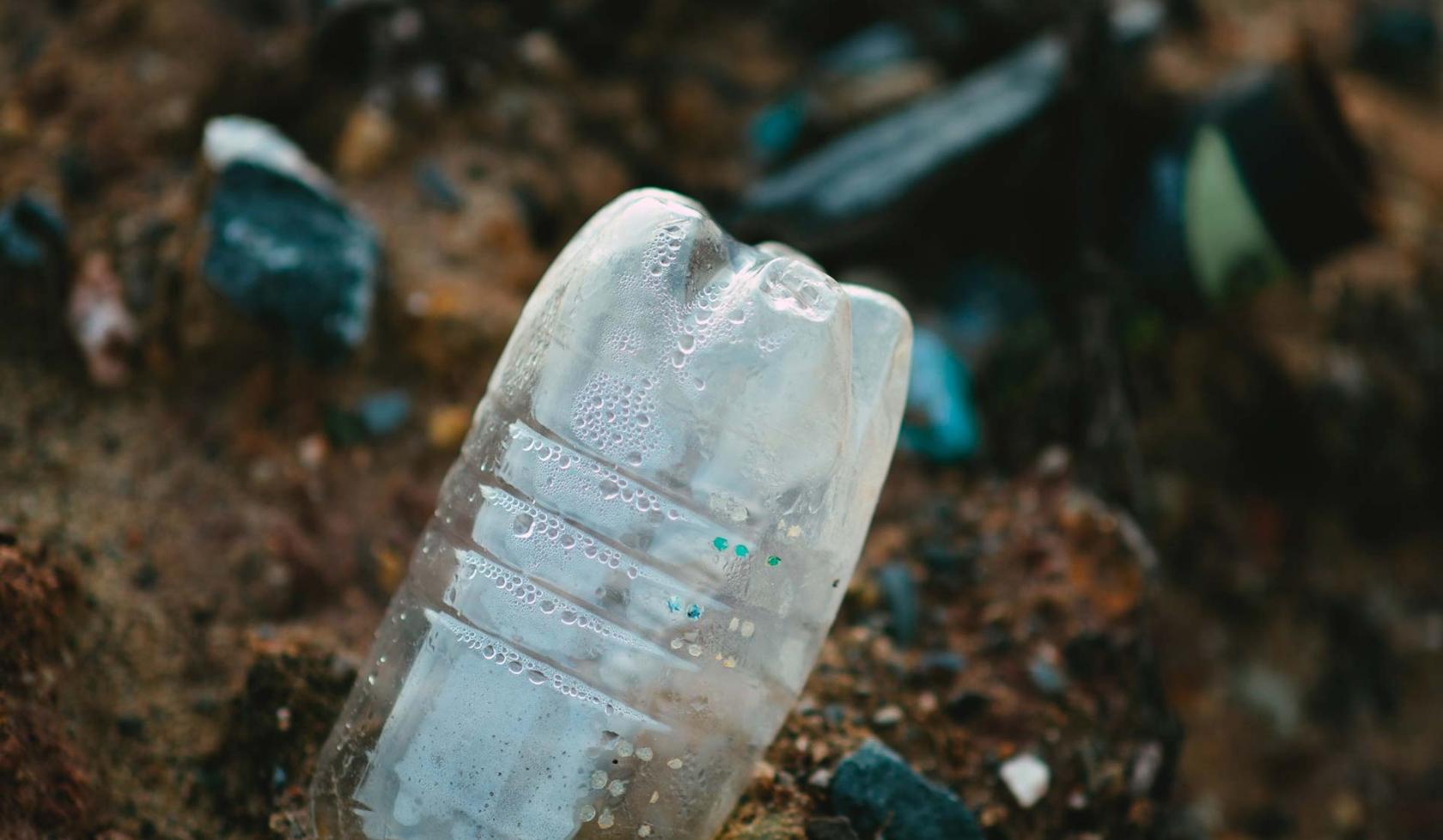 A trashed water bottle littering the land