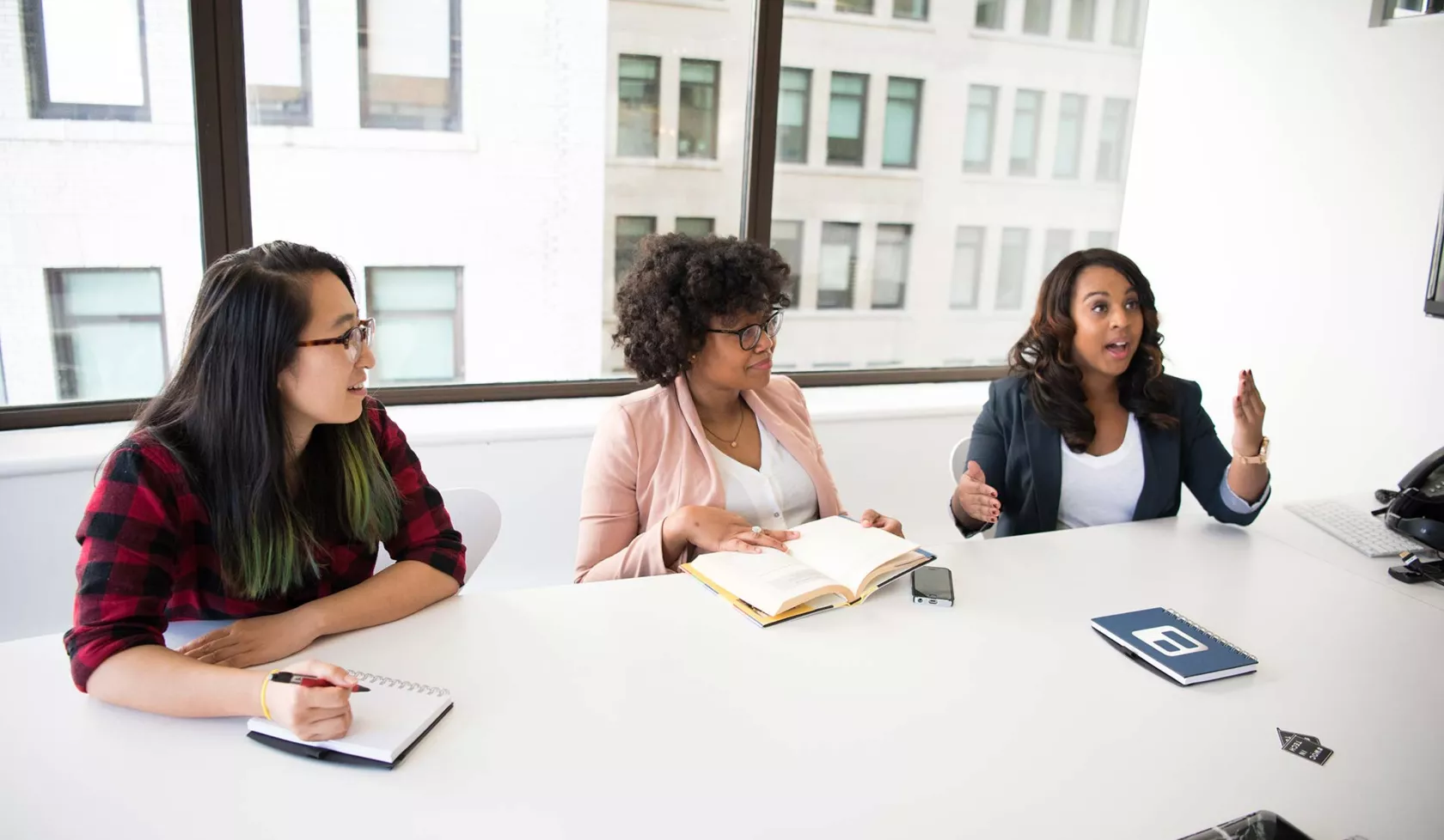 Three Young Females Working Together at an Office Table