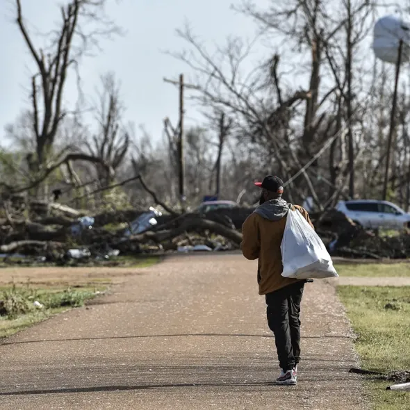 Terry York, a Silver City, Miss., resident, walks through a damaged neighborhood with a small bag of personal belongings, Saturday, March 25, 2023, after a deadly tornado ripped through the area the night before.