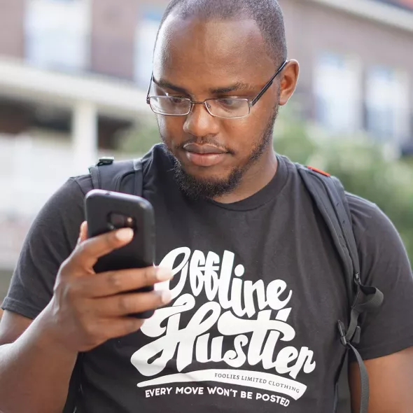 Young Black Male - Outdoors - Looking at Cell Phone