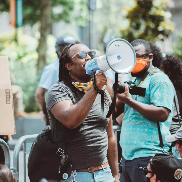 Black Male - Outdoors - Speaking to Group from Bullhorn