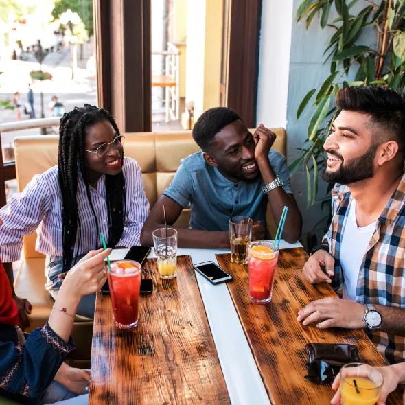 Smiling Group Interacting with Each Other at Table in a Restaurant