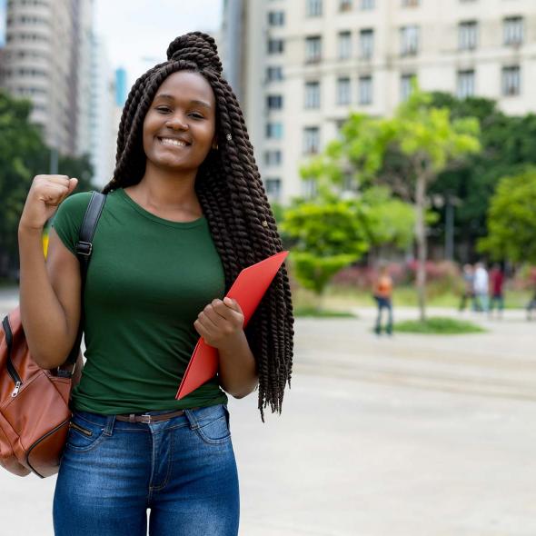 Young Black Female Outdoors- Smiling - Raising Fist