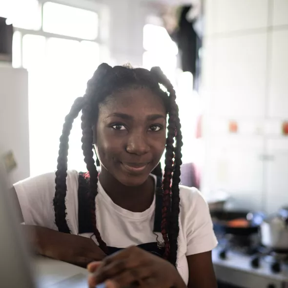 Smiling Young Girl with Open Laptop in Home