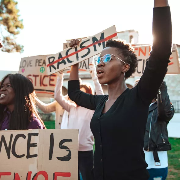 Young Adults Protesting - Holding Signs