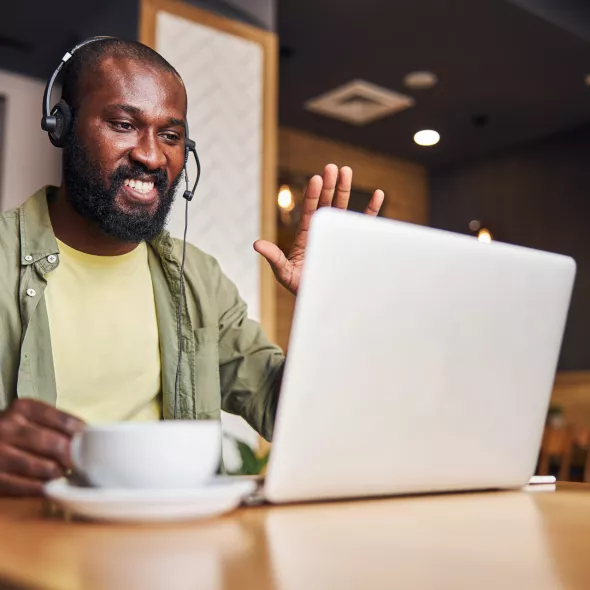 Black Man Wearing Headset on a Laptop Computer Meeting