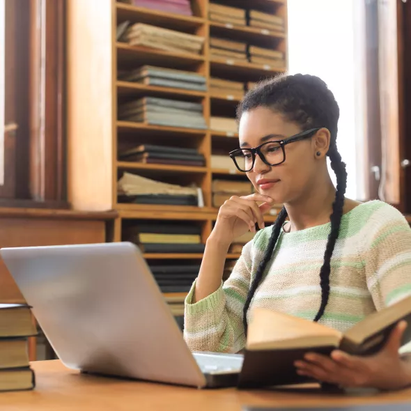 Young Black Student Working on Laptop and Studying Books