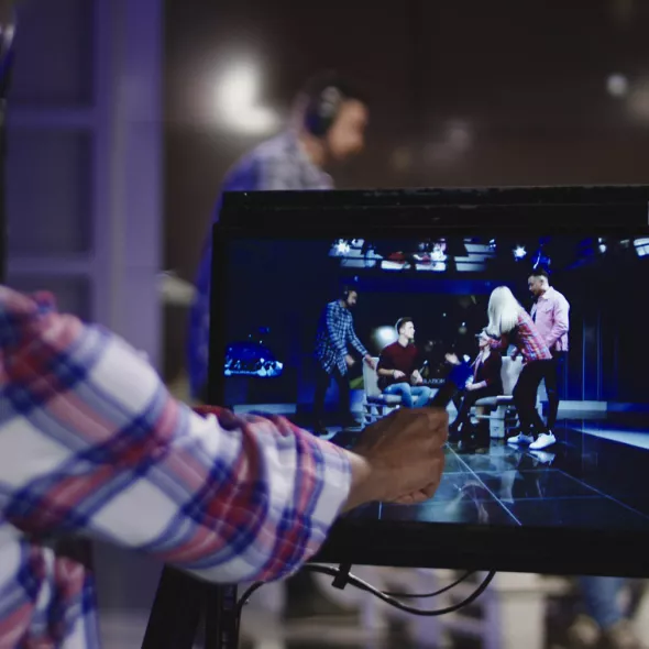 Producer Examining Monitor During Stage Performance Filming