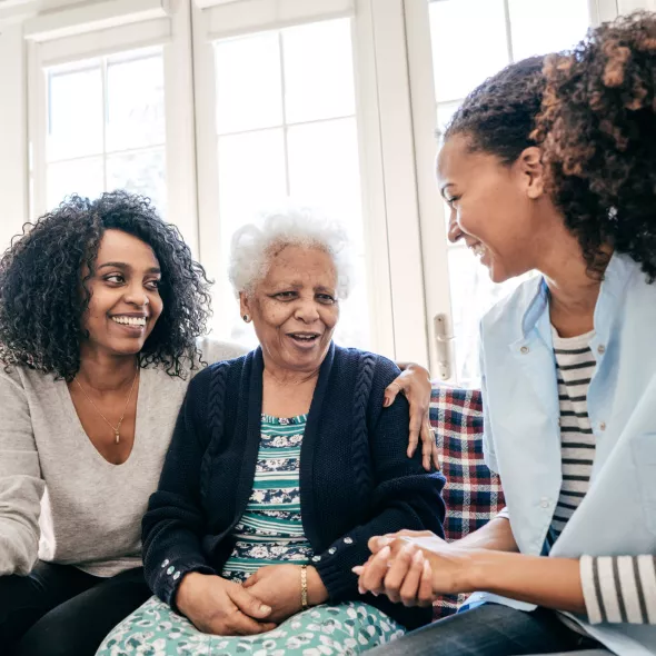 Three Black Women Sitting Down on Couch and Talking with Each Other