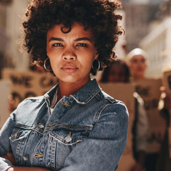 Young Black Female - Standing with Protesters with Arms Crossed