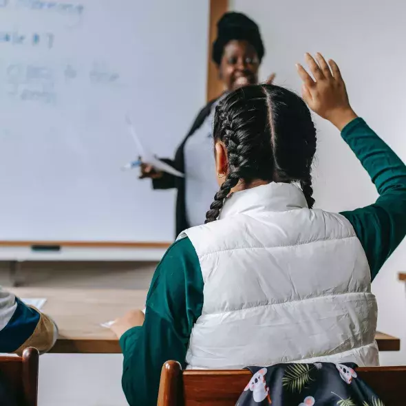 Young Black Female - raised hand - classroom setting - Black Female Teacher