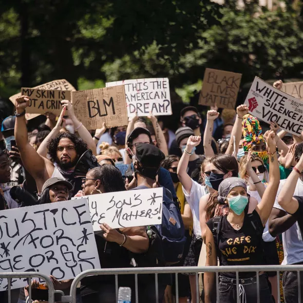 Group at march or rally or protest - holding signs - wearing face masks
