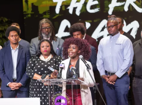 People of color standing at a podium for a press conference