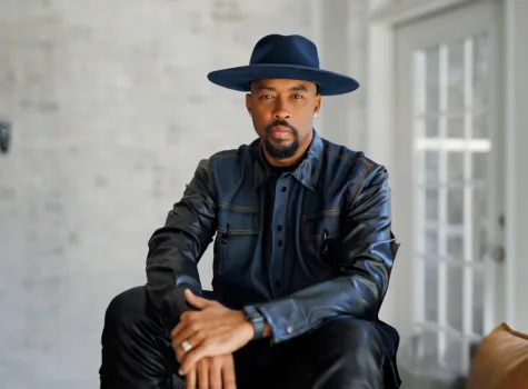 Headshot of Montell Jordan seated in a brown chair