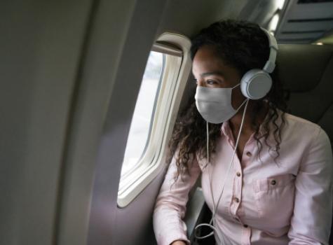 Lady wearing mask on airplane - COVID