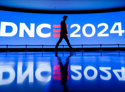 Person walks past DNC digital wall