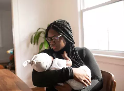 Black Female - seated - holding baby