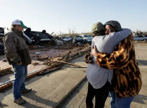 Tracy Hardin, center, who with her husband Tim, left, own Chuck's Dairy Bar, consoles a neighbor in Rolling Fork, Miss., Saturday, March 25, 2023