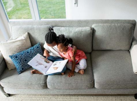 Young Black Female Children Reading Together on Couch