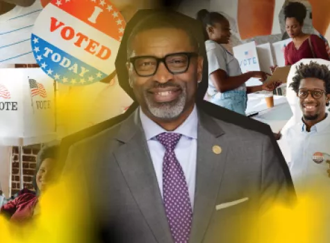 Headshot of Derrick Johnson with voting paraphernalia in the background