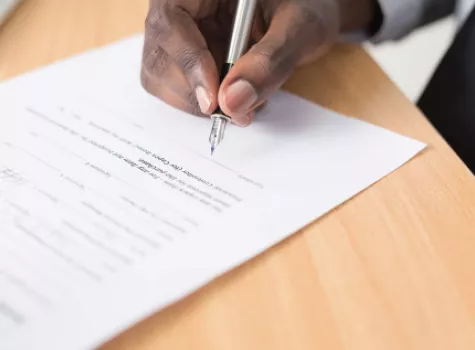 Close-Up of Black Male Hand Signing Document