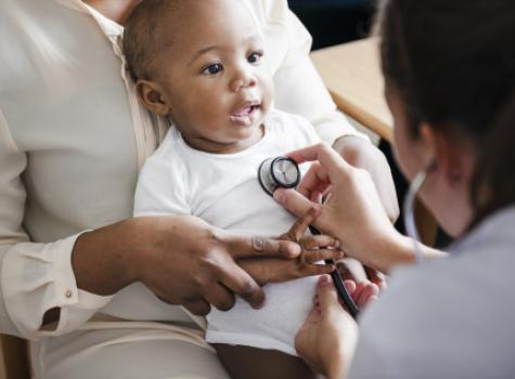 Baby with Doctor's Stethoscope on Chest at Medical Appointment